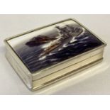 A white metal pill box with ceramic lid depicting a battleship. Box stamped 925.