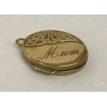 A 9ct gold oval locket with Celtic design & 'Mum' engraved to front.