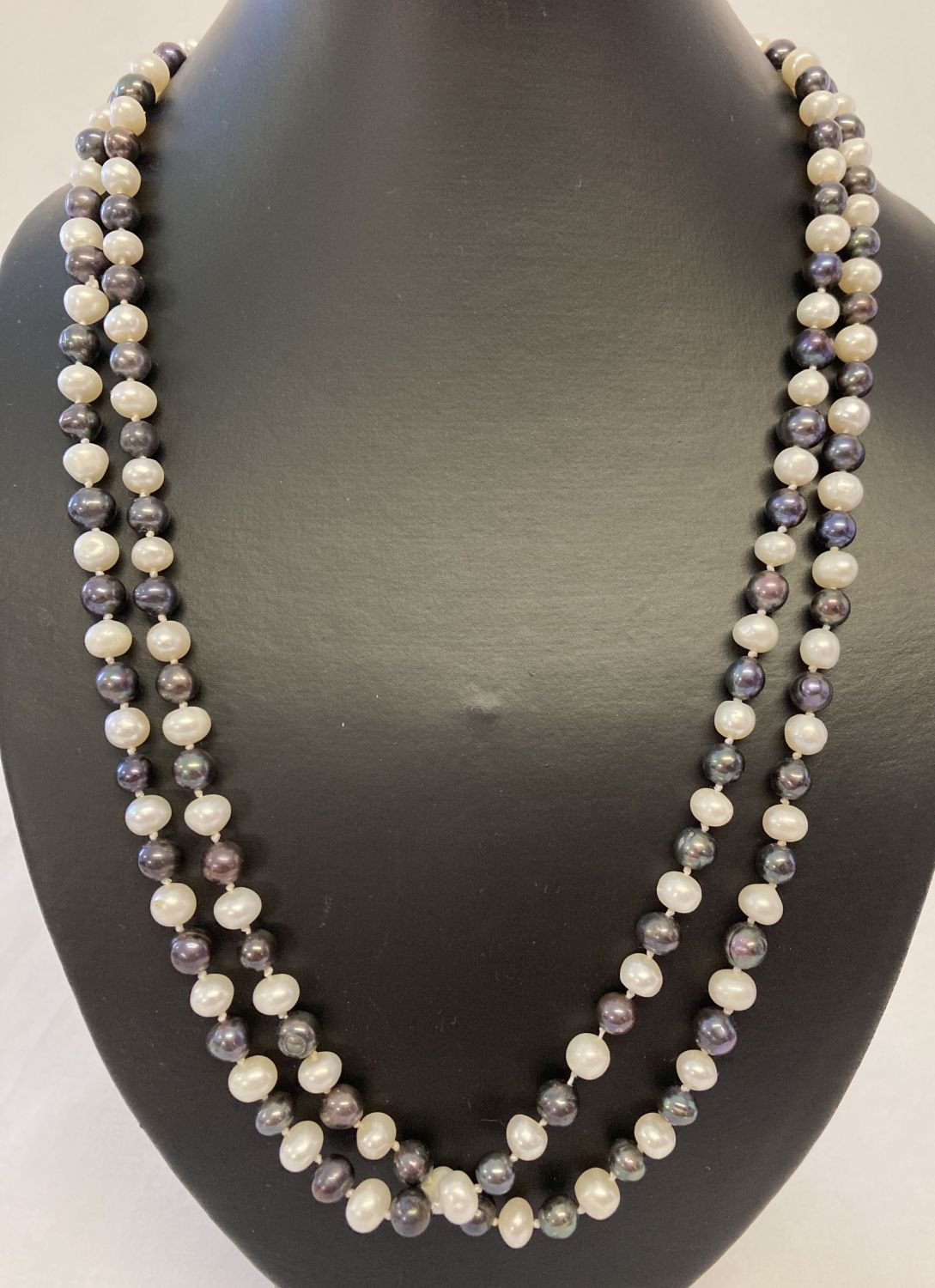 A 48" string of alternate cream and peacock freshwater pearls.