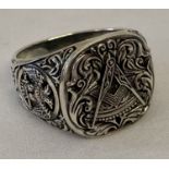 An engraved white metal ring with Masonic detail.