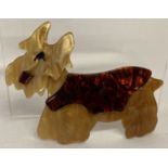 A lea Stein style Lucite pin back brooch in the form of a Scotty dog.