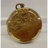 A vintage 9ct gold front and back round locket with half floral engraving to front.