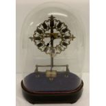 An antique Bulle electric clock with ornate brass skeleton frame and oval shaped glass dome.