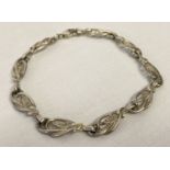 A decorative silver bracelet with Art Nouveau style links and lobster style clasp.