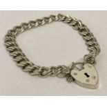 A vintage silver double belcher chain charm bracelet with padlock and safety chain.