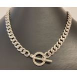 A heavy silver curb chain necklace with t bar and clear stone set fixing ring.
