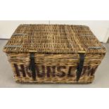 A Victorian wicker laundry basket with leaded banding, eel skin hinges and leather straps.
