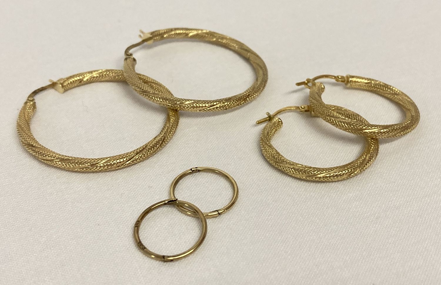 3 pairs of 9ct gold hoop style earrings.