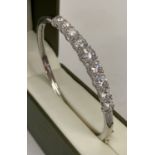 A silver hinged bangle set with graduating round cut cubic zirconia stones.