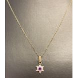 A 9ct gold drop pendant necklace. Flower shaped pendant set with central amethyst and diamonds.