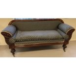 A decorative Victorian mahogany settee with carved panels to arms and turned legs.