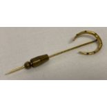 A vintage gold horseshoe stick pin set with 7 small round cut diamonds.