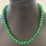 A 16" deep green Chinese Jade beaded necklace with 9ct gold ball and hook clasp.