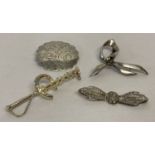 4 silver and white metal brooches.