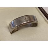 A men's silver band ring with 2000 cross mark to outside of band.