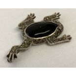 A silver, onyx and marcasite brooch in the shape of a frog.