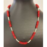 An 18" bamboo coral and fresh water pearl necklace with gold coloured T bar clasp.