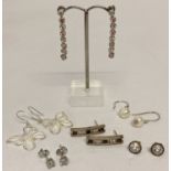 6 pairs of silver and white metal earrings in drop and stud styles.