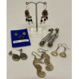 7 pairs of silver and white metal earrings in both drop and stud styles.