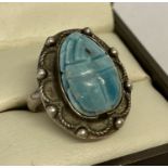 An Egyptian silver and turquoise ring carved in the shape of a scarab beetle.