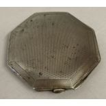 An octagonal silver compact with engine turned decoration front and back.