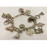 A vintage mariner style silver charm bracelet with 12 silver and white metal charms.