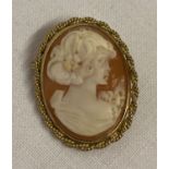 A 9ct gold classic cameo brooch with pendant bale to back. Twisted rope design to mount surround.