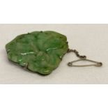 A vintage carved jade brooch in the from of a bat, with white metal mount and safety chain.