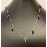 A vintage style silver necklace with faceted amethyst drops.