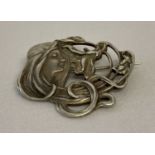 A silver Art Nouveau style brooch/pendant with classic female and floral detail.