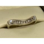 A 9ct gold Chanel set diamond wishbone style eternity ring. Approx. .15ct diamonds.