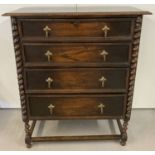 An early 20th century solid dark oak 4 drawer chest with barley twist legs and column detail.