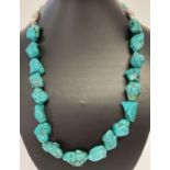 A 22" chunky turquoise and white metal beaded necklace with T bar clasp.