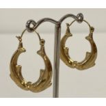 A pair of 9ct gold dolphin detail hoop style earrings. Hallmarks to posts.