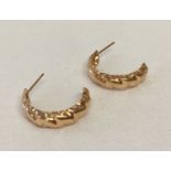 A pair of 9ct rose gold twist design half hoop earrings.