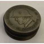 A German WWII style circular wooden snuff pot set with metal top and bottom plate.