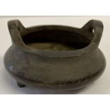 A Chinese bronze 2 handled censer with tripod feet and loop handles.