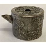 A small Chinese white metal teapot with bamboo detail to sides and Chinese characters marked to top.
