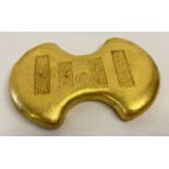 A large Chinese gold coloured metal Yuabao wealth ingot, with impressed Chinese markings & symbols.