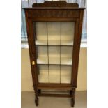 A vintage oak display cabinet with leaded glass front on barley twist legs.