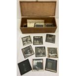 A vintage wooden box containing glass negative plates.