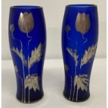 A pair of dark blue glass vases with silver Art Nouveau style floral decoration.