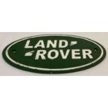 A painted cast metal oval shaped Land Rover wall hanging plaque.