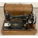 A vintage wooden cased hand Singer sewing machine with floral gold decoration.