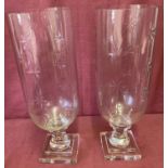 A pair of cut glass vases raised on pedestal stems with cut flower shaped detail.