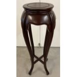 A vintage mahogany Chinese style plant stand with carved detail and curved legs.