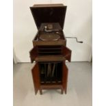 A vintage mahogany cased "His Master's Voice" gramophone with a small collection of 78 records.
