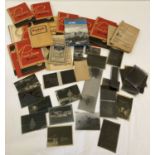 A box of assorted vintage photographic negatives, many in advertising paper packets.