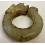A Chinese Jade roundel in the form of a carved dragon head. Detail to both sides.