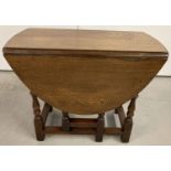 A solid oak drop leaf gate leg coffee table.